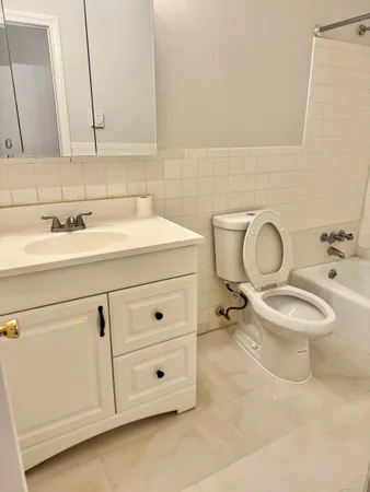 a bathroom with a toilet a sink and mirror