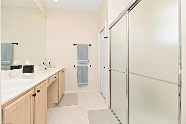 a bathroom with a double vanity sink a mirror and a shower