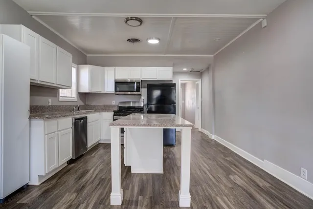 a kitchen with a refrigerator and a stove top oven