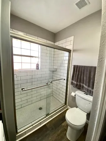 a bathroom with a toilet and a shower