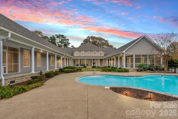 a front view of a house with swimming pool having outdoor seating
