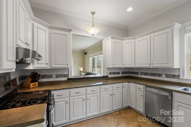 a kitchen with granite countertop a sink stainless steel appliances and cabinets