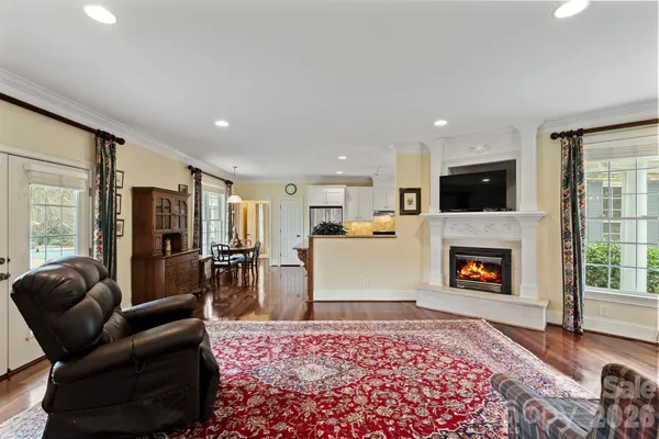 a living room with furniture a chandelier and a rug