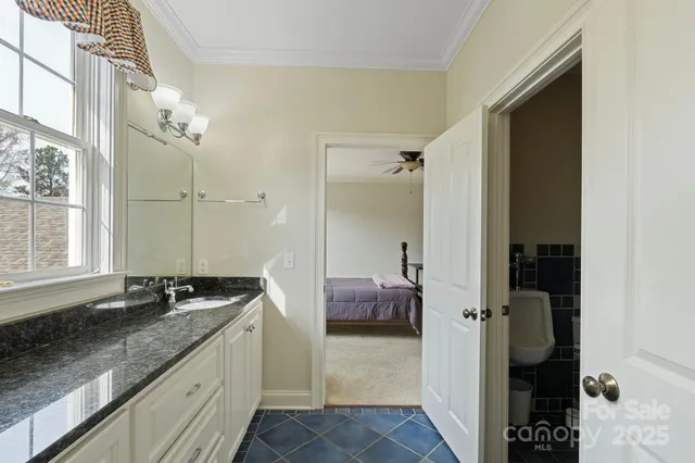 a spacious bathroom with a granite countertop sink a mirror and shower