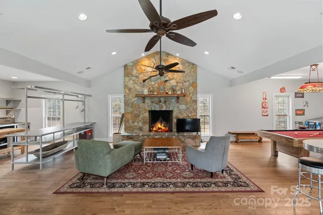 a living room with furniture a fireplace and a chandelier
