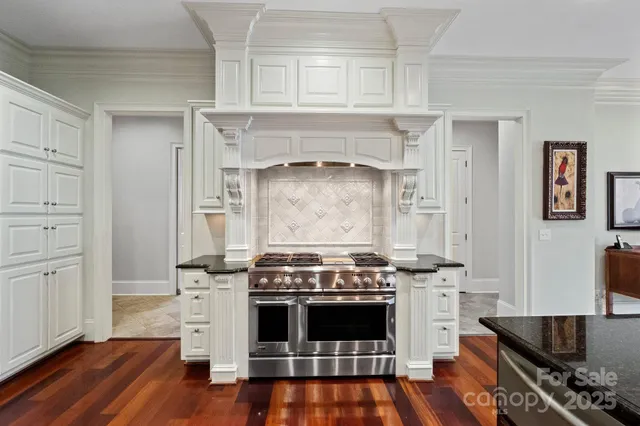 a kitchen with a stove and white cabinets