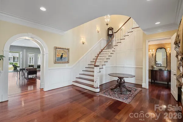 a kitchen with stainless steel appliances granite countertop a stove top oven a sink dishwasher and a refrigerator with wooden floor