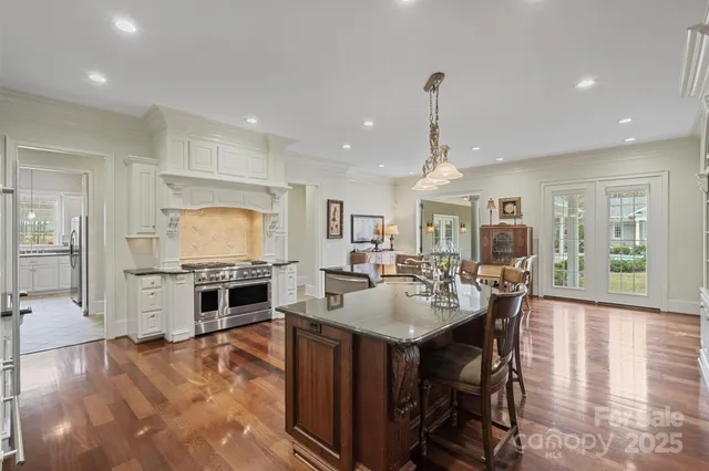 a large kitchen with sink a stove and chairs