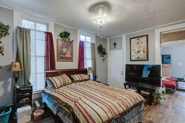 a bedroom with a bed dresser and a flat tv screen