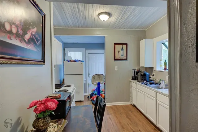a hallway with a flower pot and a bookshelf
