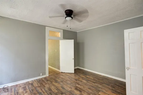 a view of an empty room with wooden floor