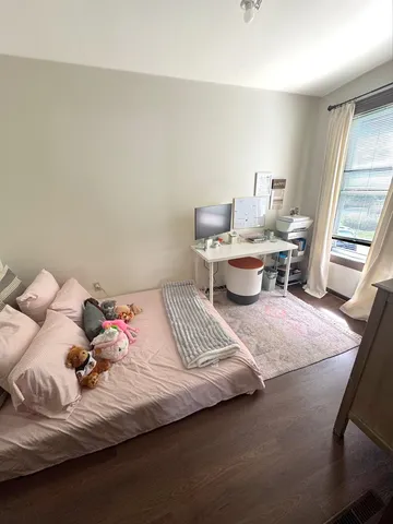 a bedroom with a bed and wooden floor