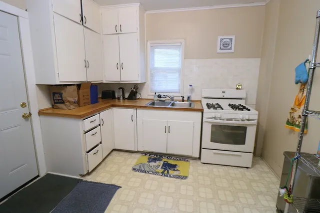 a kitchen with white cabinets and white appliances