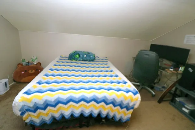 a bed sitting in a bedroom next to a lamp