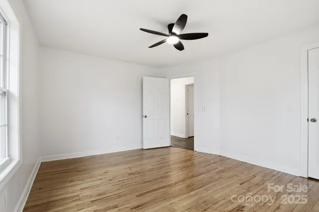 a view of a big room with wooden floor and windows