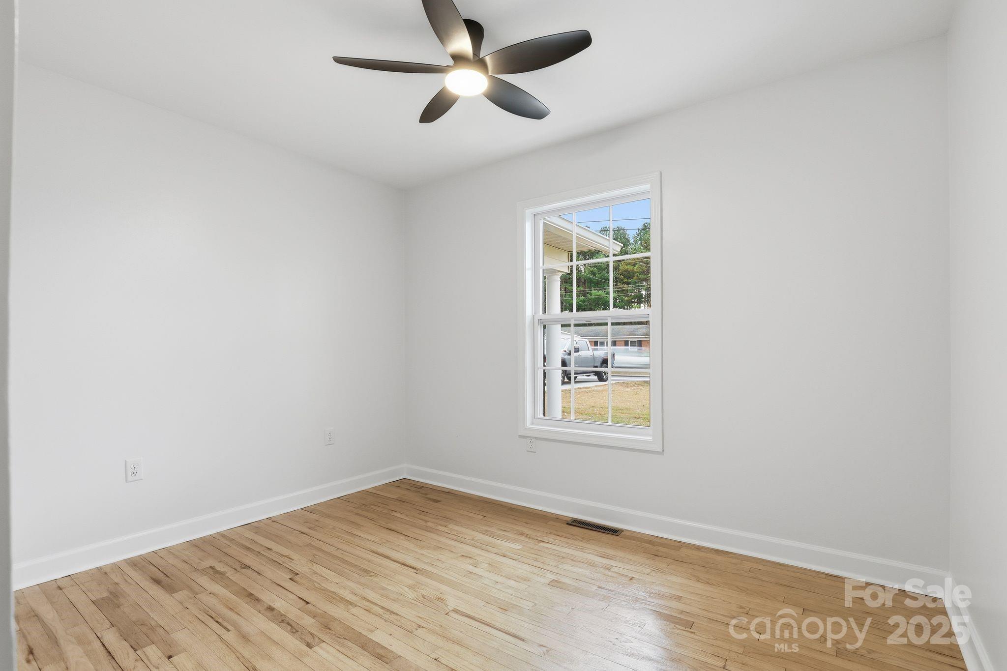 1618 Union Grove Road Lenoir, NC 28645 - Photo 14 of 24 an empty room with wooden floor ceiling fan and windows