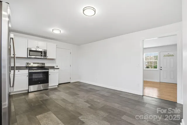 a kitchen with granite countertop white cabinets and stainless steel appliances