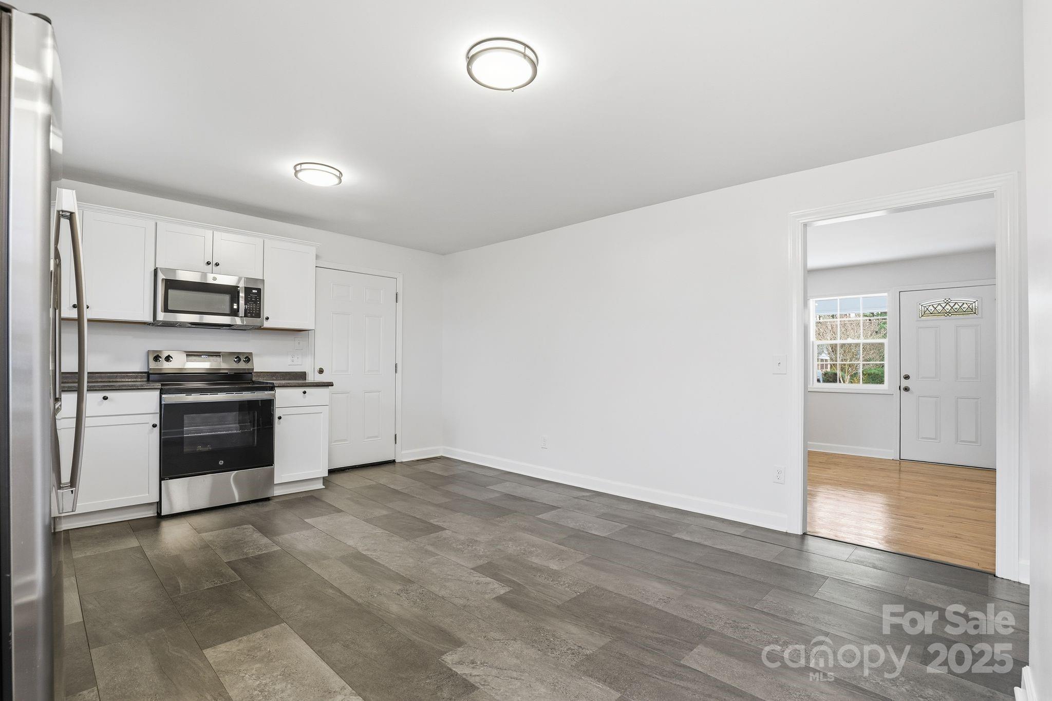 1618 Union Grove Road Lenoir, NC 28645 - Photo 19 of 24 a kitchen with granite countertop white cabinets and stainless steel appliances