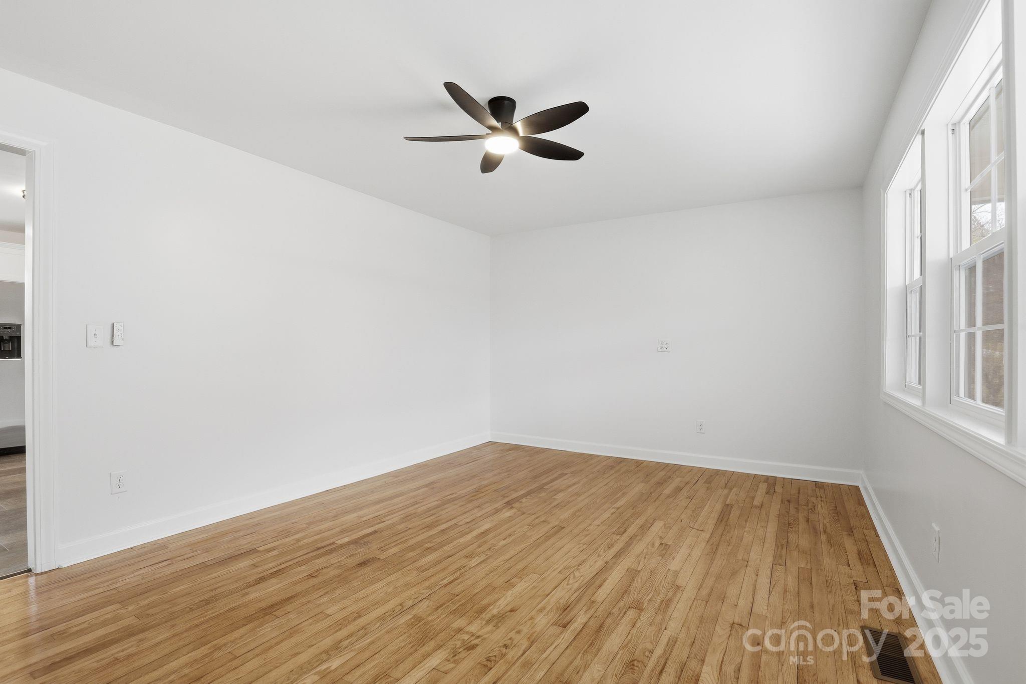 1618 Union Grove Road Lenoir, NC 28645 - Photo 6 of 24 an empty room with wooden floor a ceiling fan and windows