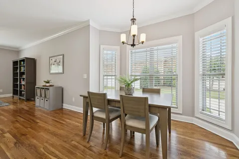 a dining room with stainless steel appliances kitchen island a table chairs and a kitchen view