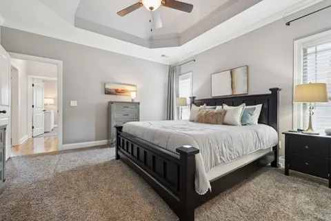 a living room with furniture a flat screen tv and a ceiling fan