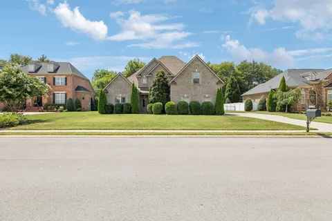 a view of a hallway with wooden floor and a living room