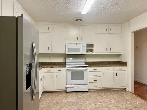 a kitchen with stainless steel appliances white cabinets and a refrigerator