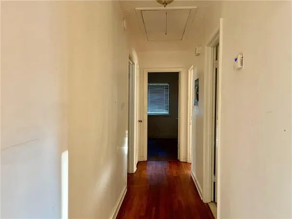 a view of a hallway with wooden floor