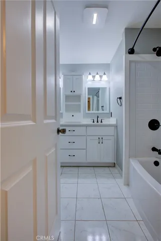 a bathroom with a bathtub a sink and a mirror