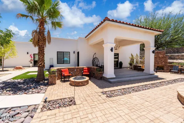 a view of a house with backyard and sitting area