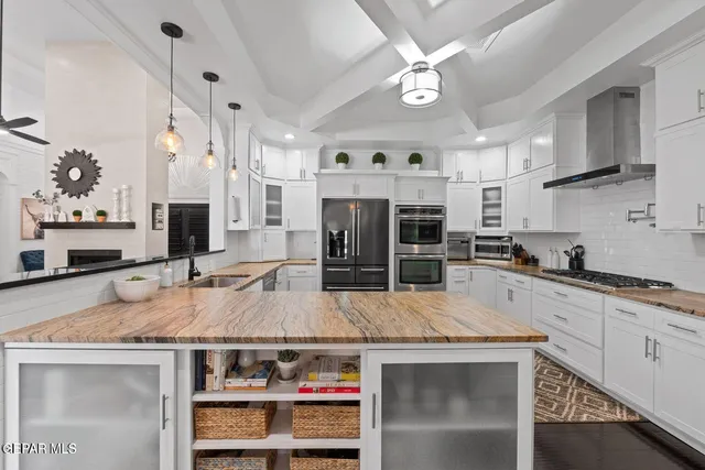 a kitchen with kitchen island a counter top space a sink stainless steel appliances and cabinets