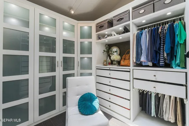 a view of walk in closet with clothes and shoes