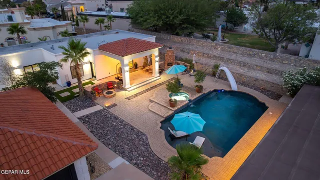 an aerial view of a house with a garden and swimming pool