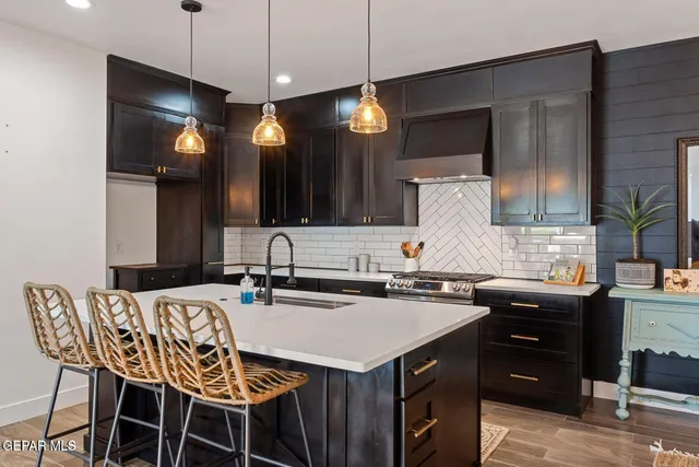 a kitchen with a sink a counter space appliances and cabinets