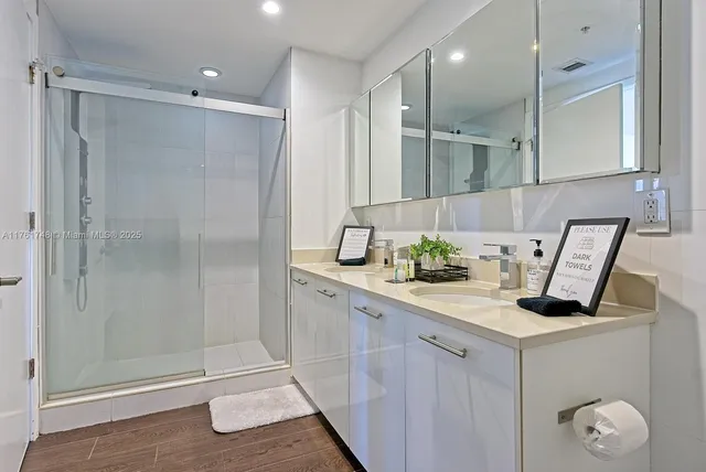 a bathroom with a granite countertop sink mirror and shower