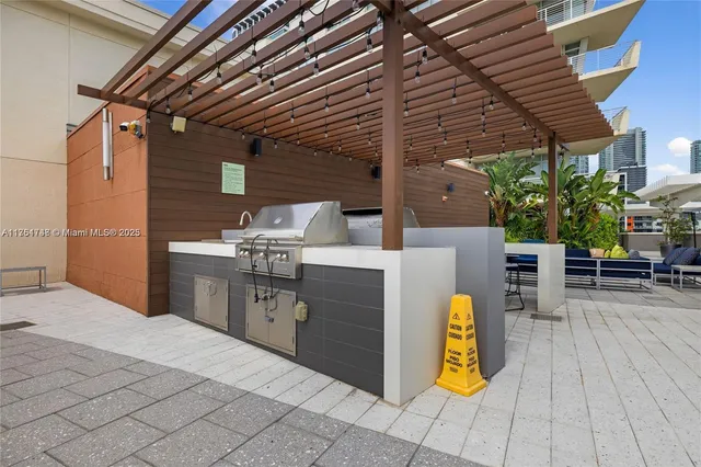 a kitchen with stainless steel appliances kitchen island granite countertop a sink cabinets and wooden floor
