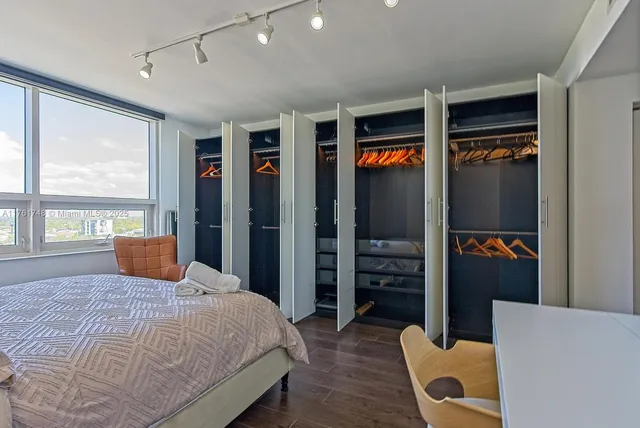 a bedroom with a bed closet and a large window