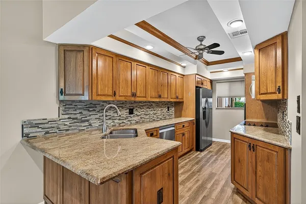 a kitchen with stainless steel appliances granite countertop a sink stove and refrigerator