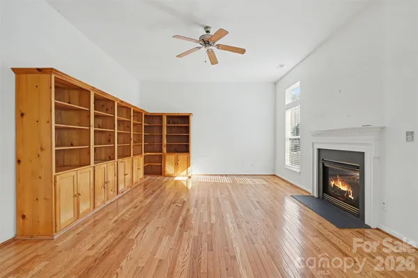 a view of empty room with wooden floor and fireplace