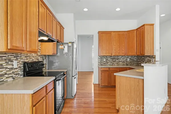 a kitchen with stainless steel appliances granite countertop a sink a stove and a refrigerator