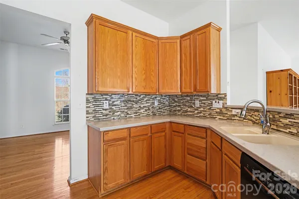 a kitchen with a sink cabinets and wooden floor