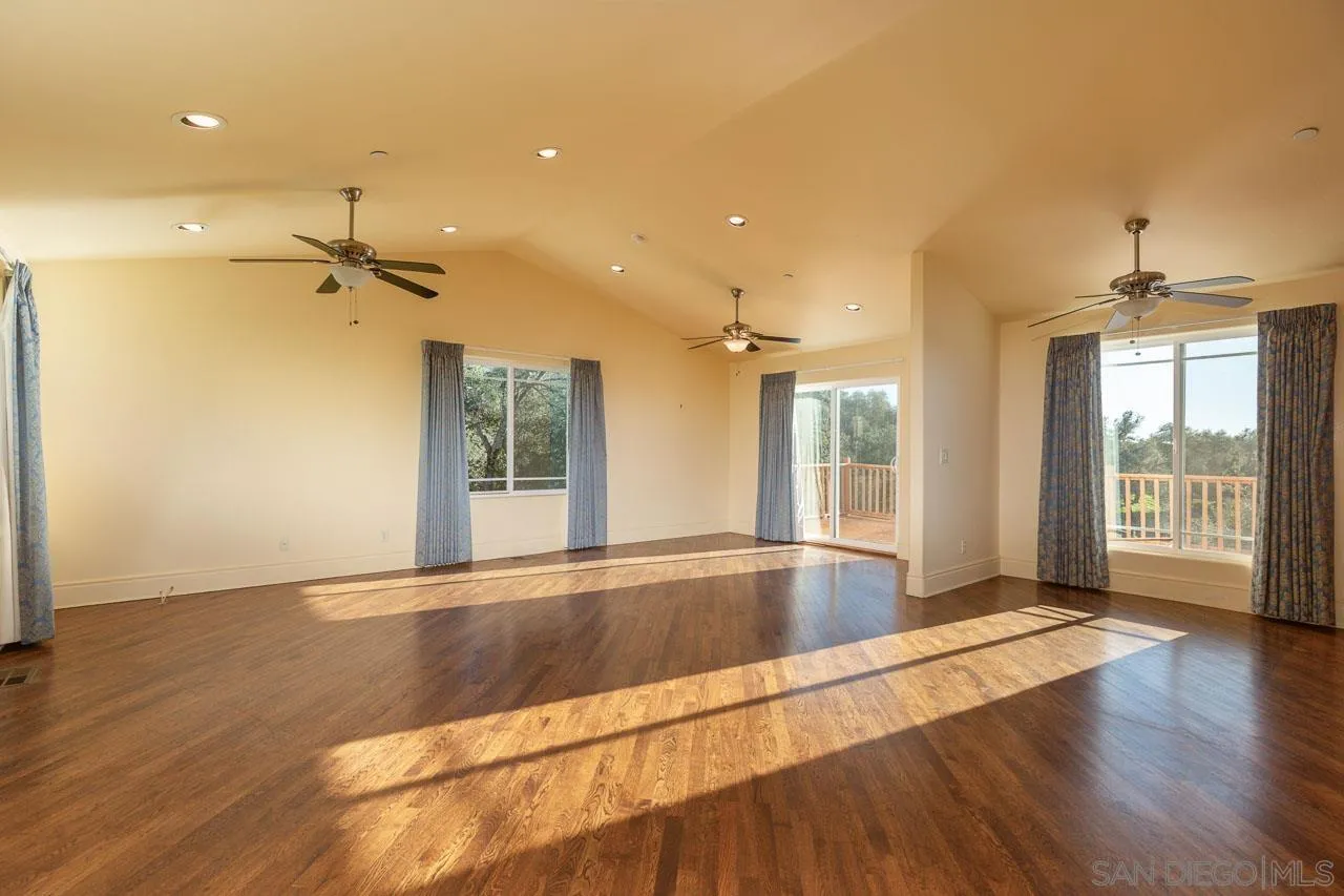 1328 Riverwood Road Santa Ysabel, CA 92070 - Photo 3 of 31 a view of an empty room with wooden floor and a window
