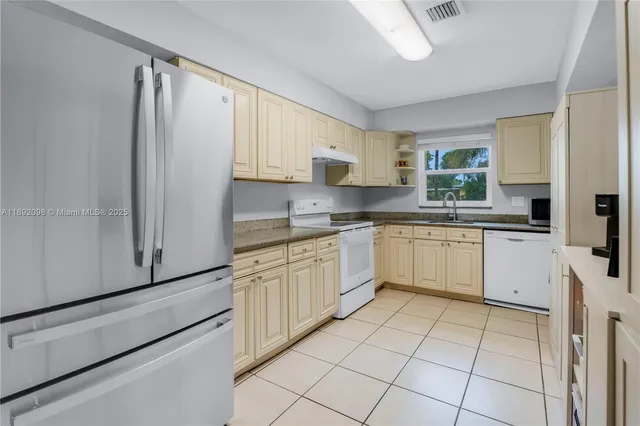 a kitchen with white cabinets and white appliances