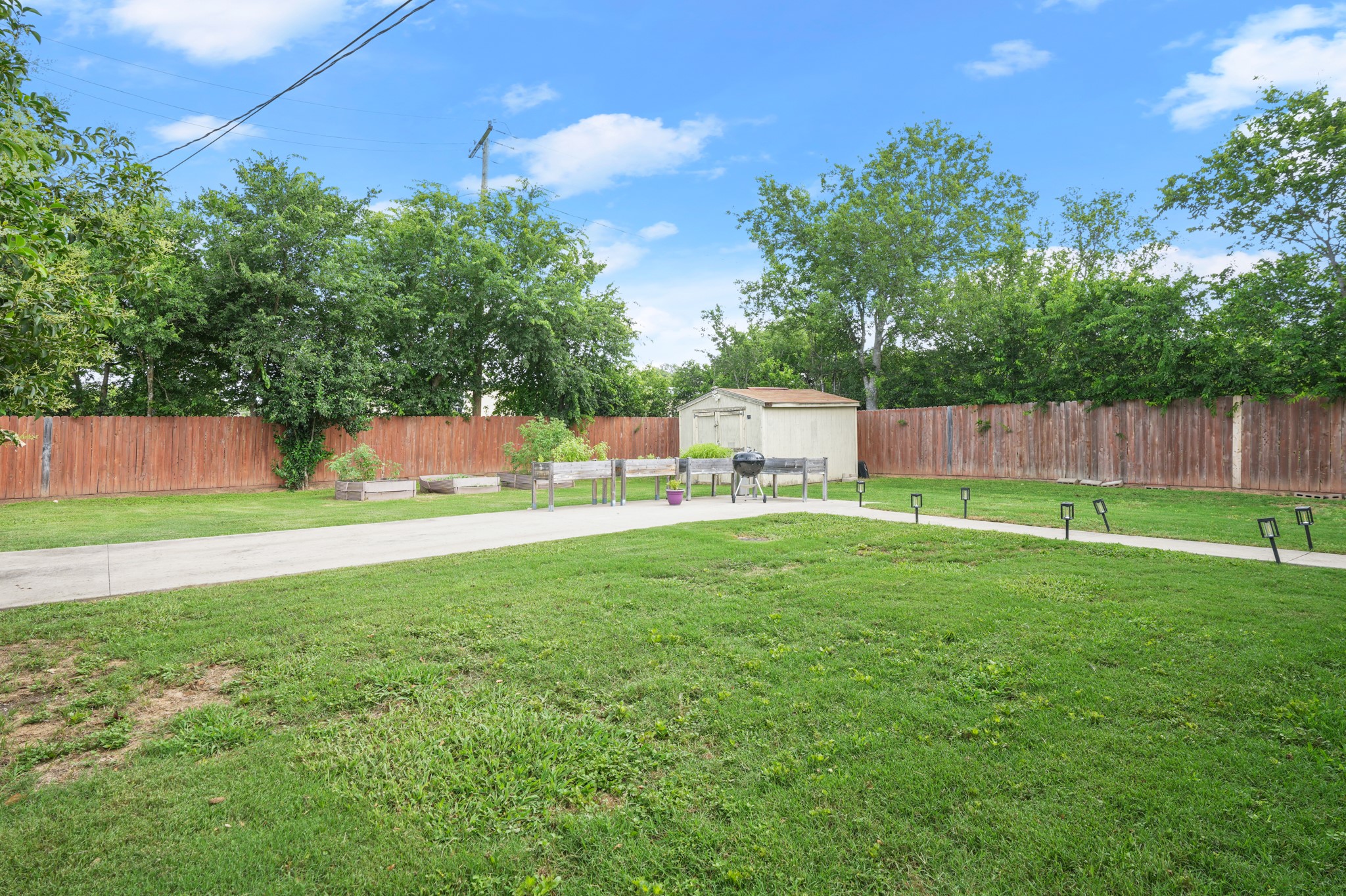 301 Old Thorndale Road Taylor, TX 76574 - Photo 25 of 29 A fenced backyard retreat featuring a storage shed and defined pathway.