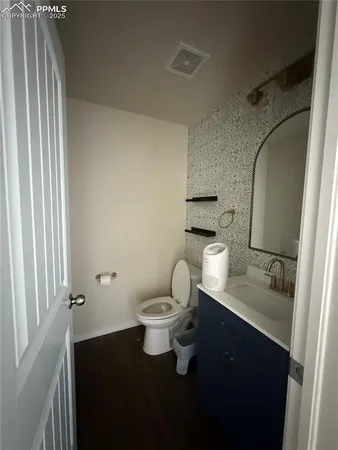 a bathroom with a toilet a sink and mirror