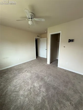an empty room with a ceiling fan and closet