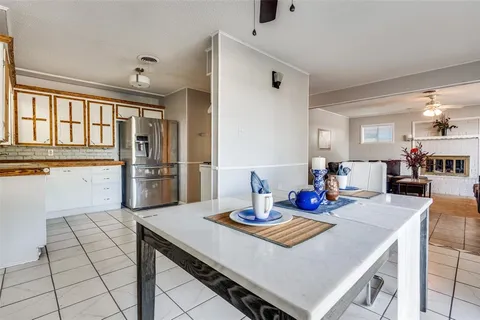 a kitchen with stainless steel appliances granite countertop a stove a refrigerator and a dining table with wooden floor