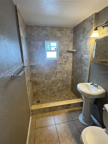 a bathroom with a sink a toilet and shower