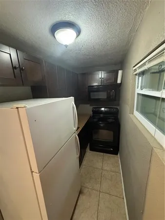 a kitchen with a refrigerator and a counter top space