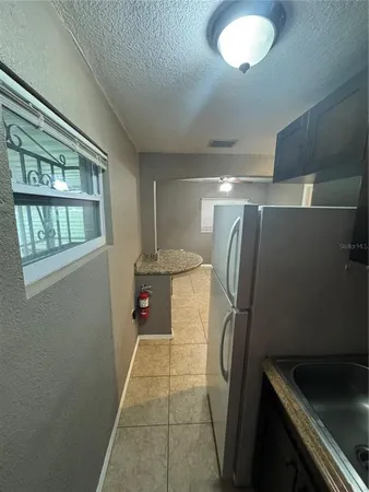 a kitchen with stainless steel appliances granite countertop a sink and a refrigerator